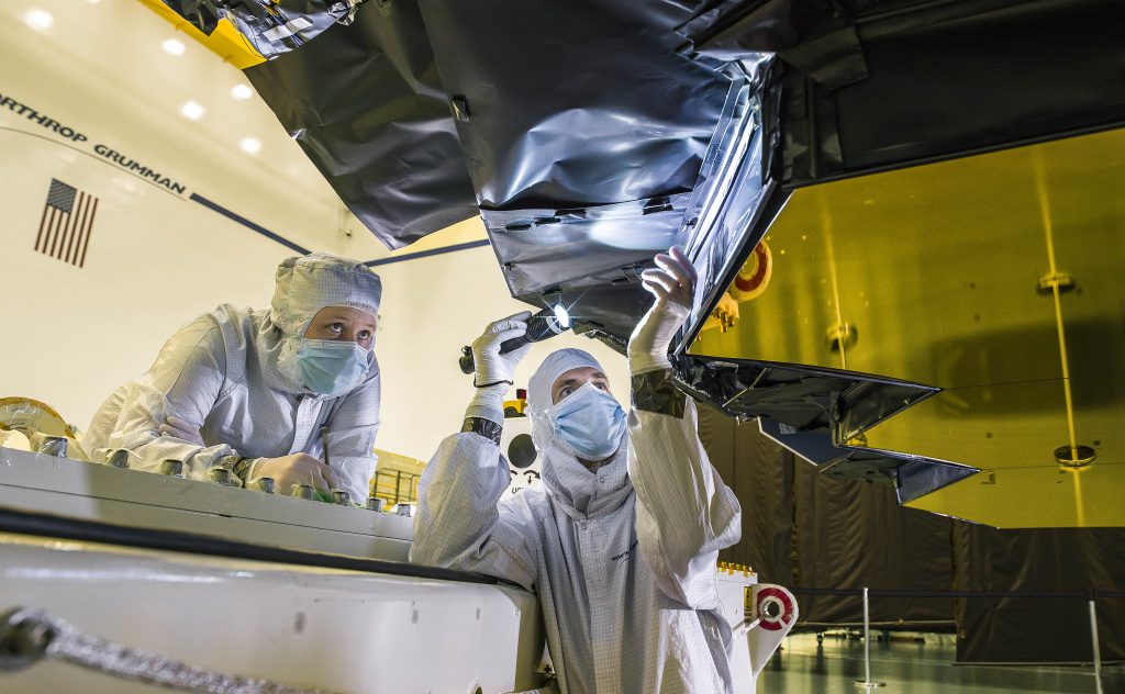 Northrop Grumman blanket technician Ann Meyer, and Ball Aerospace optical engineer Larkin Carey inspect the protective barrier.