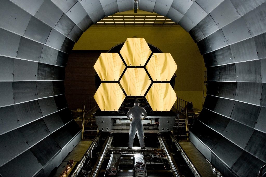A NASA engineer observes segments of the primary mirrors of the James Webb Space Telescope.