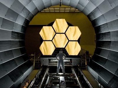 A NASA engineer observes segments of the primary mirrors of the James Webb Space Telescope.