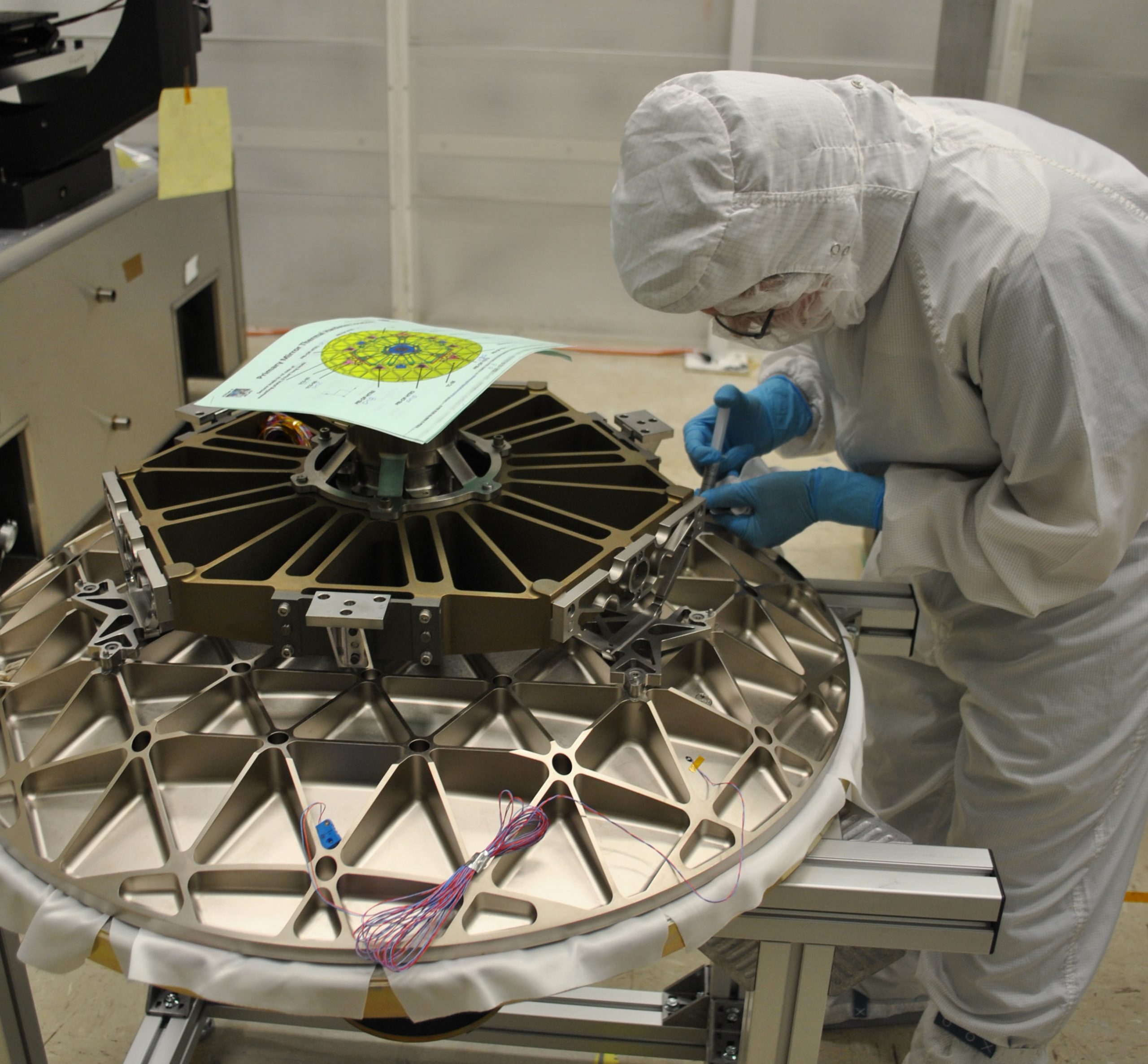 An engineer attaches components to ICESat-2's beryllium telescope, before it is attached to the satellite's ATLAS instrument.