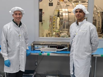 GSFC engineers Austin Tanner (left) and Manuel Vega (right) at NanoRacks clean room facility in Houston, TX during the integration of the SNOOPI cubesat into the deployer.