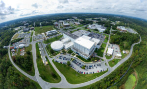 A view high above the Integration and Test complex (center) places it in the broader context of the NASA Goddard campus. Building 29, the prominent rectangular structure, is home to the largest high-bay clean room in the world. The circular building left of center houses the High Capacity Centrifuge, which is used to simulate launch and landing loads on spacecraft hardware. Imaged Oct. 5, 2023, looking south-southwest.