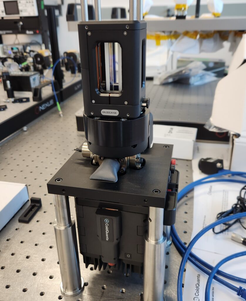 Photonically integrated Cs cold atom source and three-dimensional magneto optical trap cooling chamber