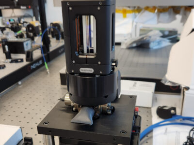 Photonically integrated Cs cold atom source and three-dimensional magneto optical trap cooling chamber