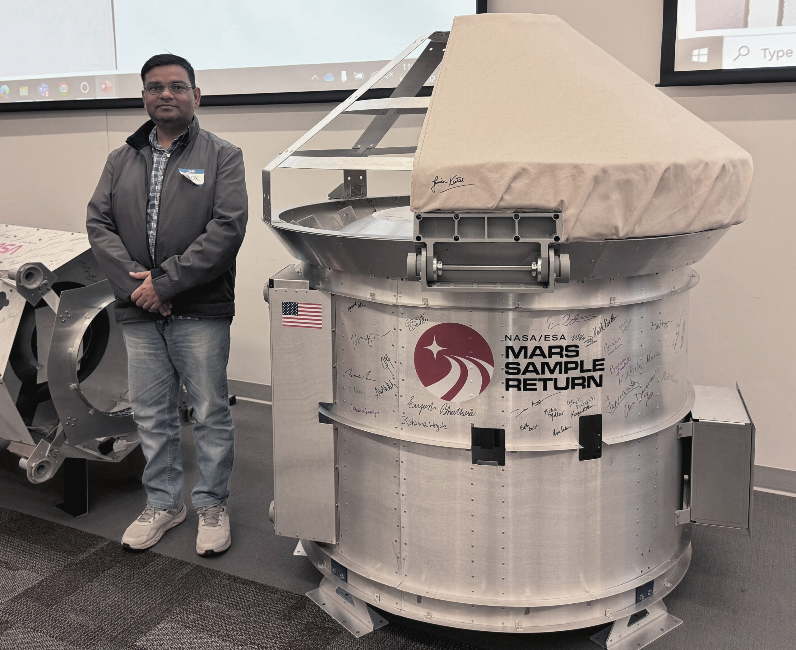 Dr. Ashok Prajapati stands next to the MSR-CCRS (Mars Sample Return - Capture Containment and Return System) prototype. It used cFS for Flight Software. Photo Credit: NASA