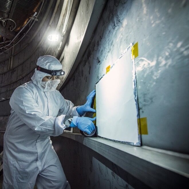 Nithin Abraham, Thermal Coatings Engineer, installs a Molecular Adsorber Coating panel in a thermal vacuum chamber for JWST space environment testing. The thermal vacuum environment extracts absorbed contaminants from spaceflight hardware that could otherwise settled on sensitive optics and radiators. Molecular Adsorber Coating panels, instead, capture those airborne contaminants before they reach delicate surfaces