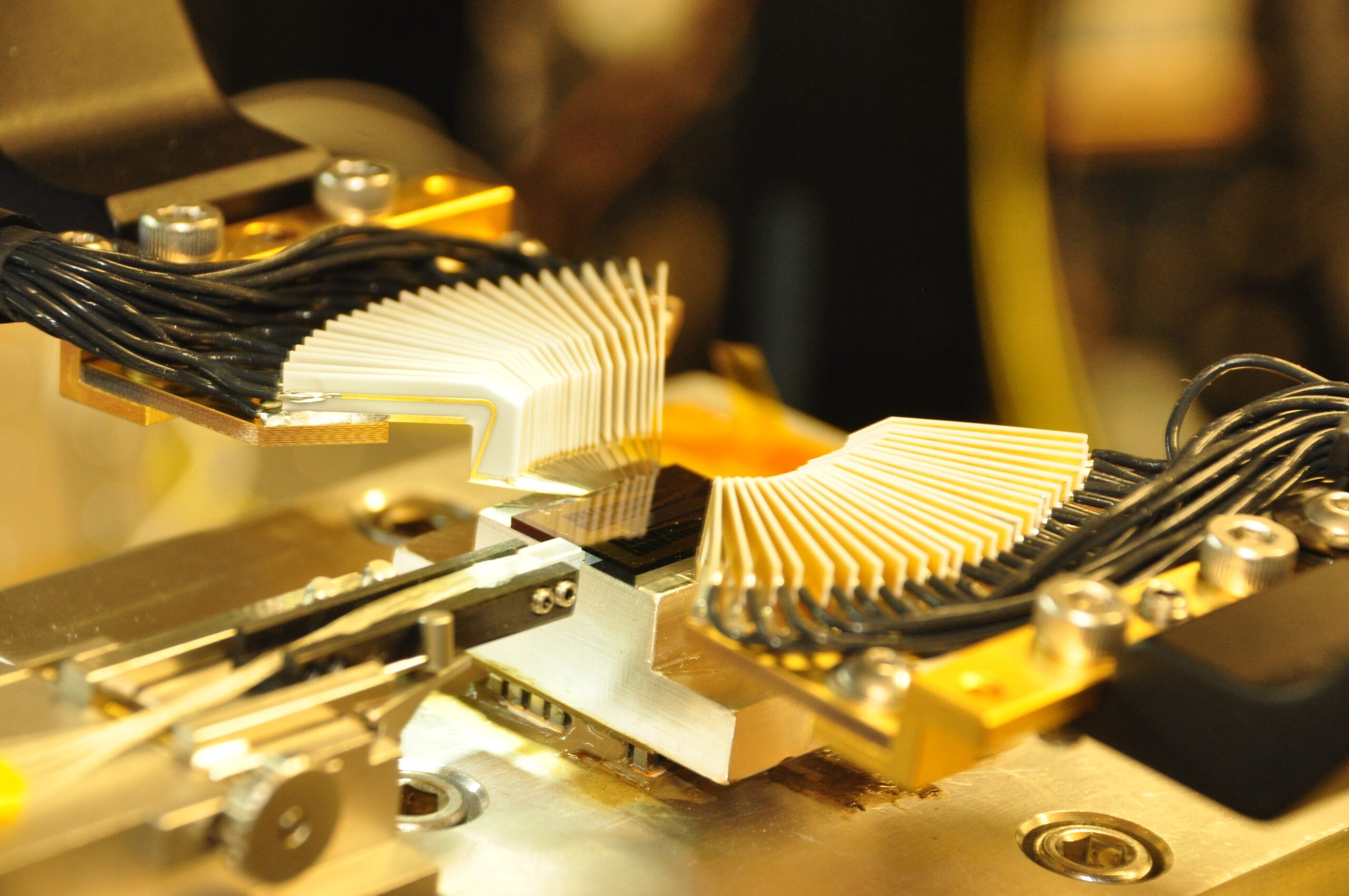 Photonic Integrated Circuit (PIC) characterization station showing multi-probe electrical and fiber array optical interfaces.