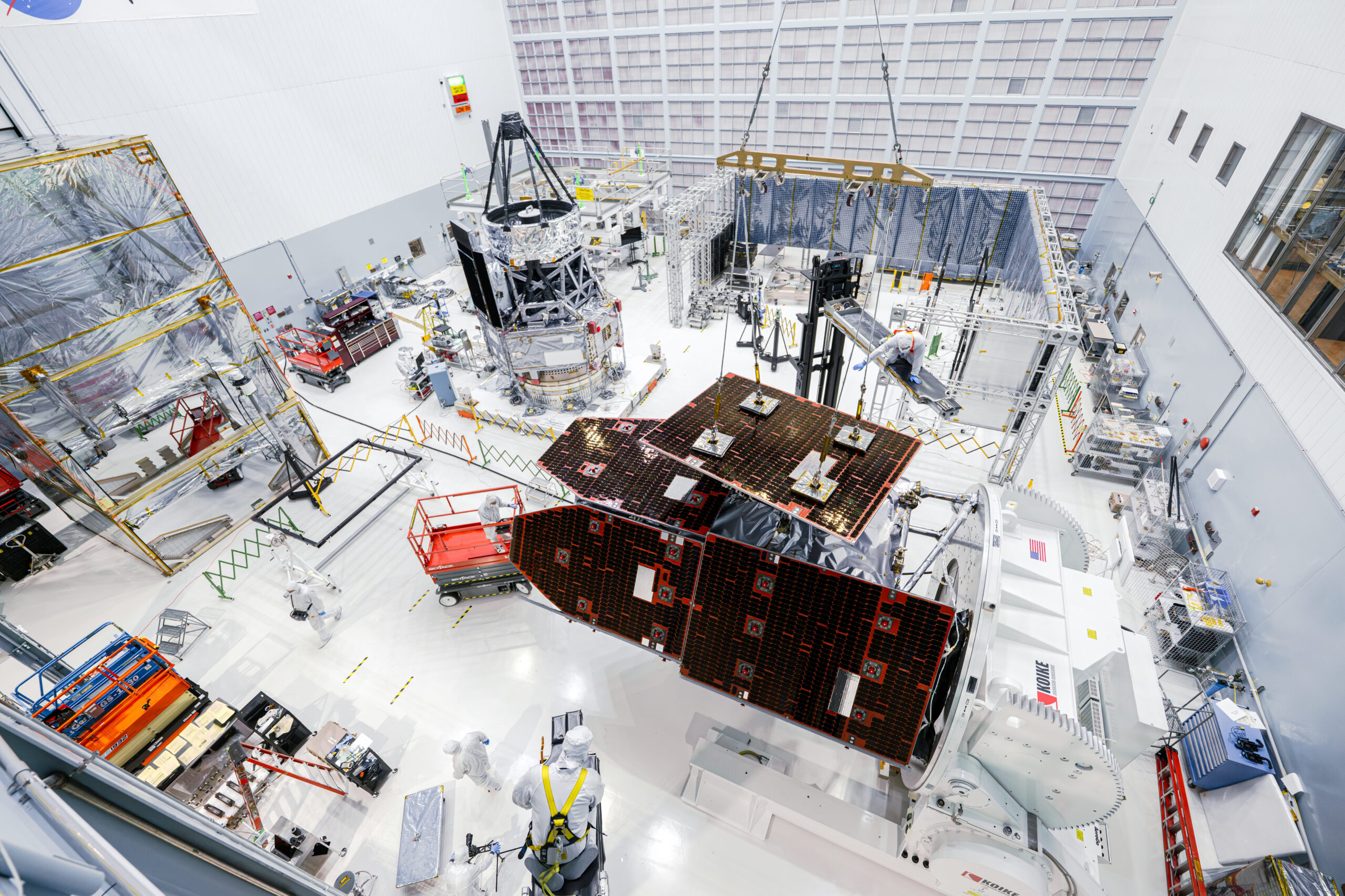 In this photo, technicians install solar panels onto the outer portion of NASA’s Nancy Grace Roman Space Telescope. Roman’s inner portion is in the background just left of center. By the end of the year, technicians plan to connect the two halves and complete the Roman observatory. Credit: NASA/Sydney Rohde